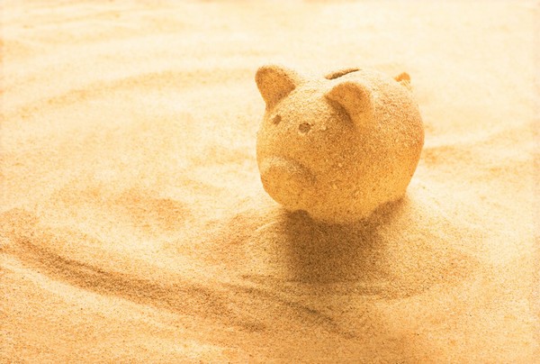 all inclusive versus self catered piggy bank made of sand