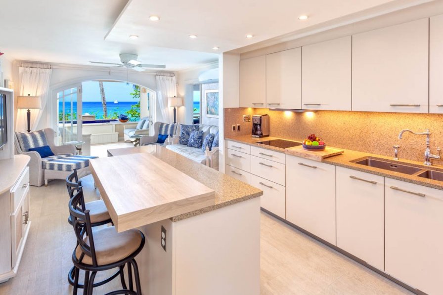 Villa in Barbados, Holetown, St. James. Inside open plan kitchen leading on to living area and then decking area outside with the beach in the far background