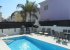 Pool area with barbecue, sun loungers and dining table and chairs