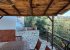 Under the pergola, with the barbecue and sink in the background.