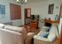 The living room: sofas, fireplace, shuttered window, tv and pictures.