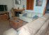 The living room with sofas, tv, coffee table, fireplace and pictures.