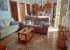 The living room: sofas, tables; the door on the left is to bedroom 2.