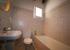 Fully-tiled 3-piece bathroom with shower over bath